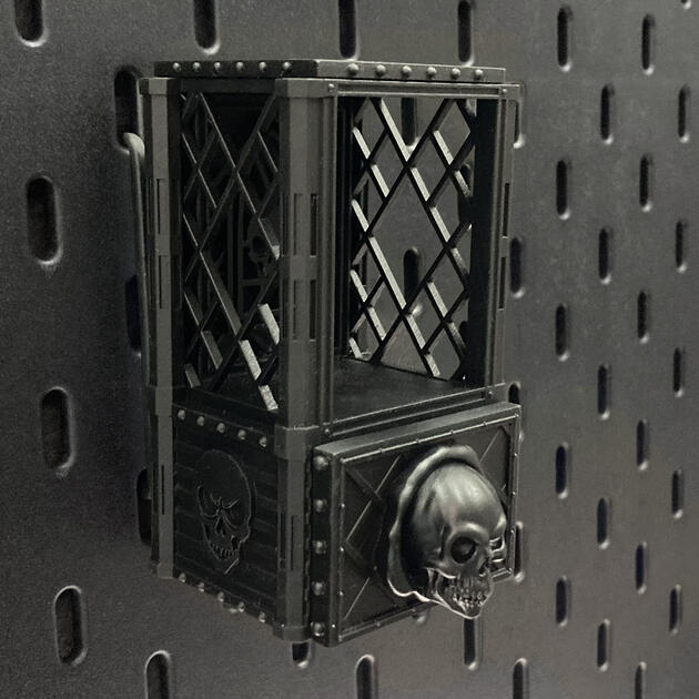 The Skull | Wall-Mounted TTRPG Organizer & Dice Drawer Hand-painted weathered iron skull dice box with open storage drawer, mounted on an IKEA SKÅDIS pegboard for TTRPG miniature display.