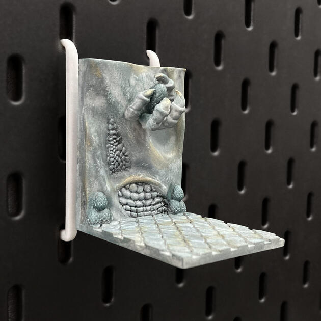 Hand-painted ancient stone dragon claw dice box, mounted on an IKEA SKÅDIS pegboard for TTRPG setup.