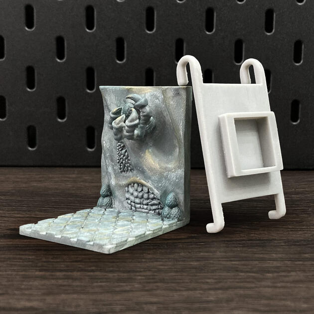Hand-painted ancient stone dragon claw dice box, mounted on an IKEA SKÅDIS pegboard for TTRPG setup.